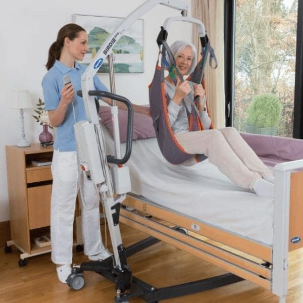 invacare birdie mobile hoist with carer, patient & bed